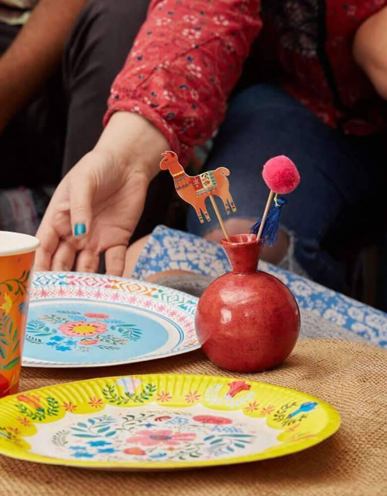 A Boho Fiesta Themed Party Table featuring Talking Tables 9" Boho Fiesta Floral Plates and boho pom pom cake toppers