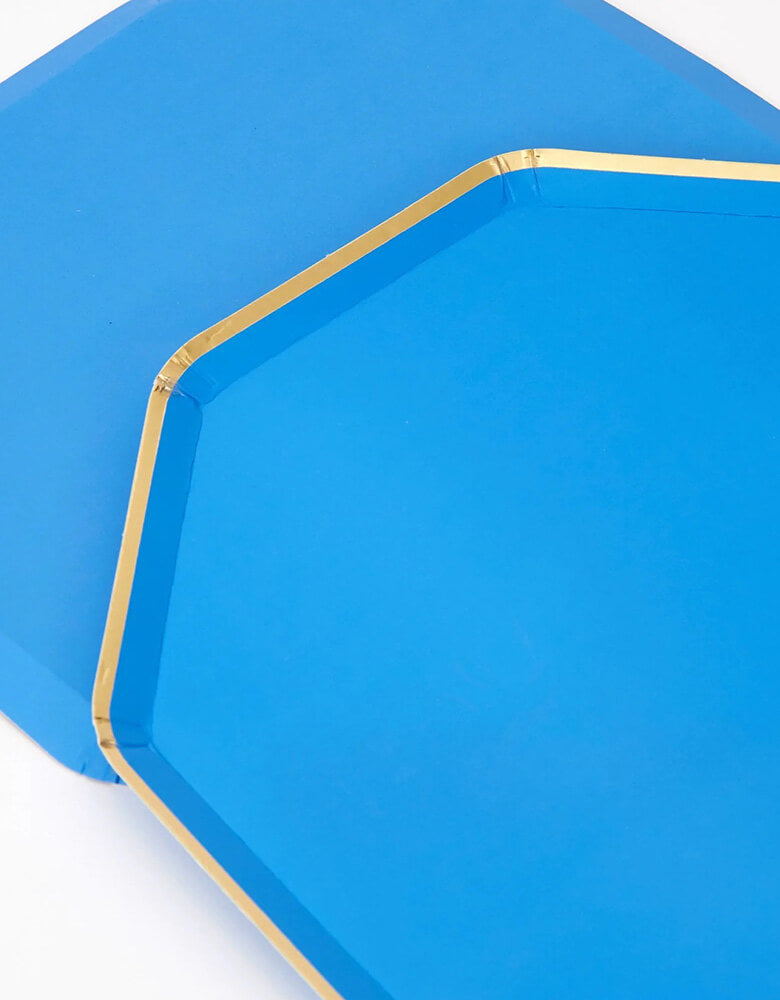 A close up of Meri Meri 10.25 inches bright blue octagonal dinner plates with gold foil edge