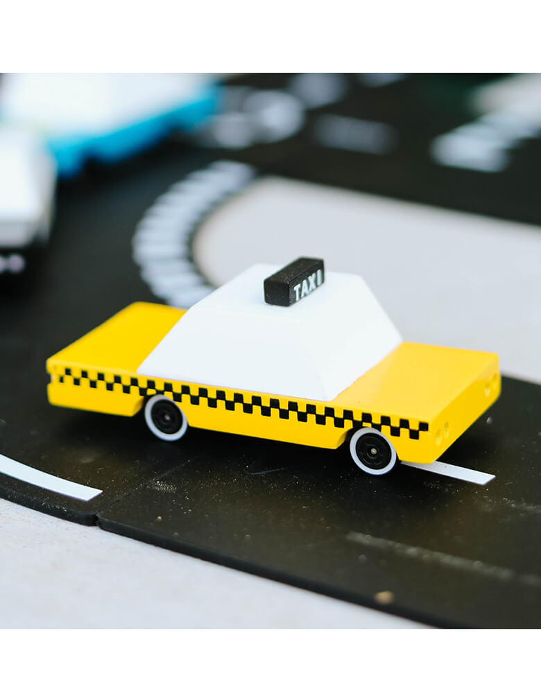 A Candylab Candycar Yellow Taxi on a toy asphalt road