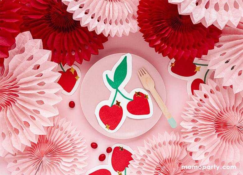 A pink and red themed party table with pastel pink round plate layered with party deco's cherry shaped die-cut napkins featuring gold star point detail, along with pink and red party fan decorations as the centerpiece of the table, it makes a simple party idea and inspiration for a girly Valentine's celebration or Ganlentine's Day party with your BFFs!