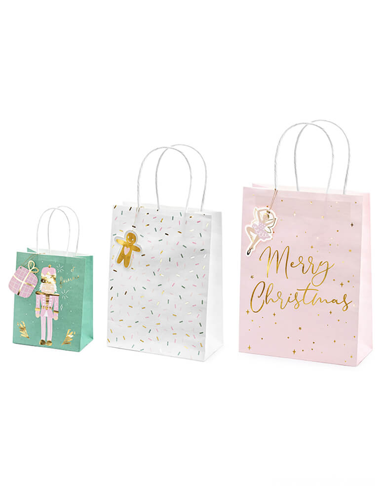 Party Deco Christmas Gift Bags, Set of 3, contains 3 designs including pink nutcracker over green bag, gingerbread man on the sprinkles white bag, and pink ballerina on the Pink bag with gold foil Merry Christmas sign. Each bag comes with a gift tag to write on it!