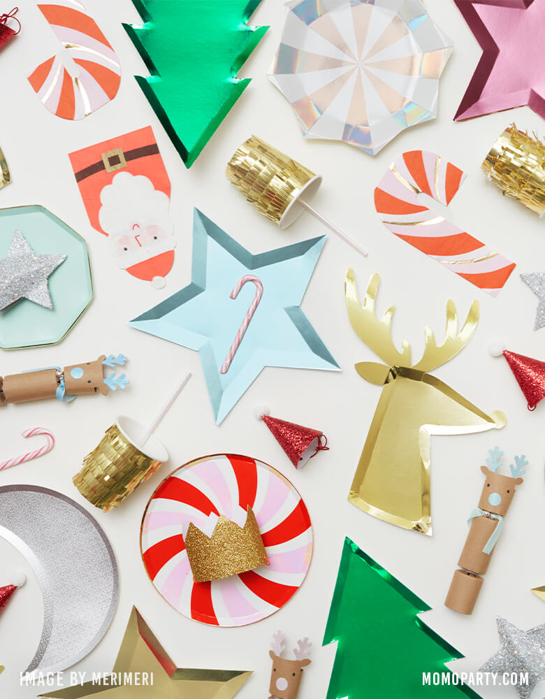 Meri Meri Holiday Tableware, Holiday party table decorated with peppermint designed plates, christmas tree green foil plates, Santa napkins, candy cane napkins and assorted gold and pink foil plates, SILVER STARBURST LARGE PLATES, GOLD FRINGE PARTY CUPS, party hats, reindeer plates, and reindeer CRACKERS