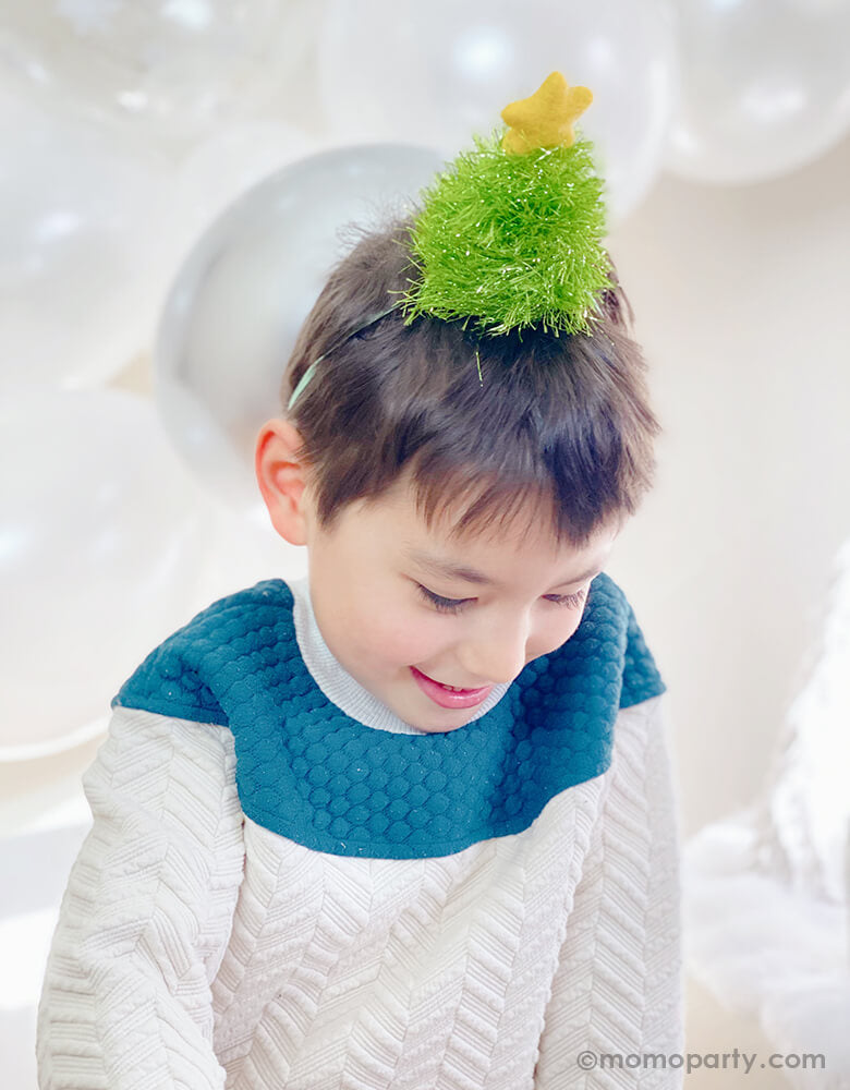 boy wearing a Christmas-Tree-Glitter-Hat with silver white balloons for a white christmas party celebration