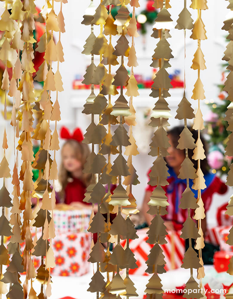 Christmas party with kids opening christmas gifts behind Party deco - Christmas Tree Gold Backdrop. This Christmas Tree Gold Backdrop Create the perfect entrance to your Christmas party with this glamorous Christmas tree fold foil curtain! Simply hang this curtain across your doorway to create a glittery surprise and a stunning backdrop for your guests.