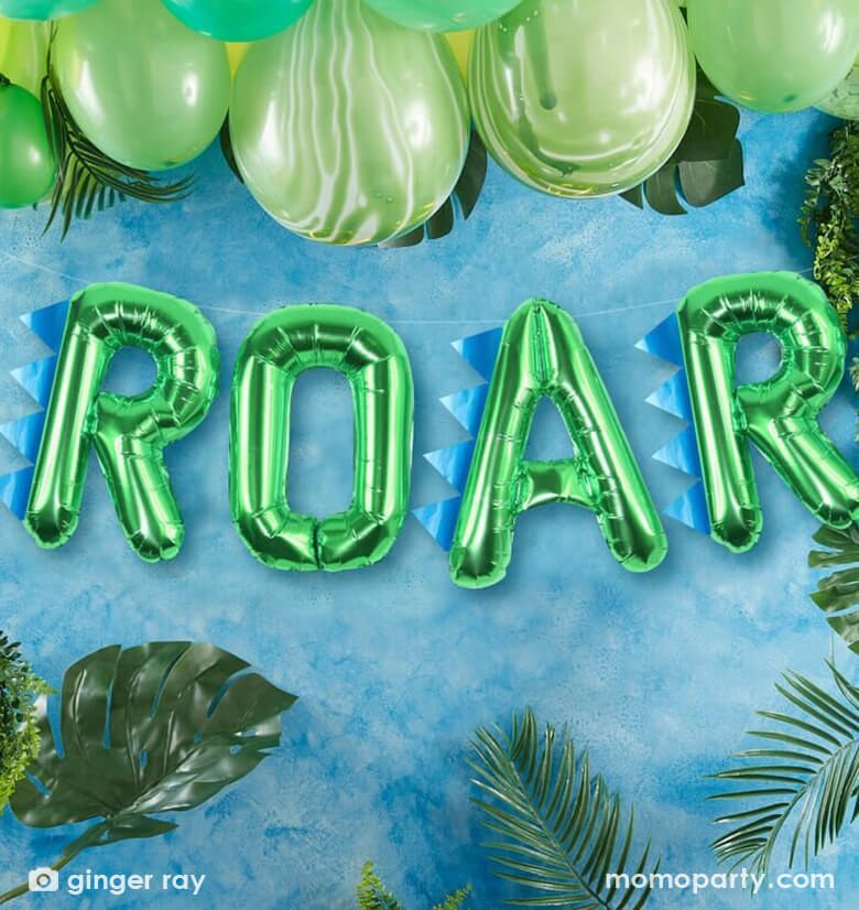 Dinosaur party decorated with Ginger Ray dinosaur party roar balloon bunting and palm leaves, green latex balloons. This dinosaur Roar Party Balloon Set contains four 16" green foil letter balloons of "R""O""A""R", and 3 dinosaur spikes and twine to hang. This Roar balloon set will be a hit at your party. The ultimate finishing touch to your dinosaur party. A fun balloon that will be loved by all! The balloons can be attached to walls and also included dinosaur spikes to attach!