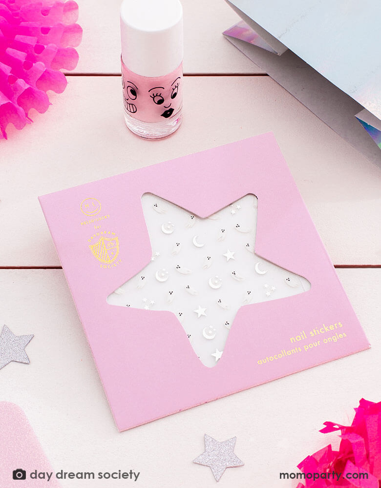 A table shot with Daydream Society Nail Sticker Sheet and a kids pink nail polish bottle, with glittered star confetti around - a perfect party favor for a not-so-spooky girly pink Kids Halloween celebration 