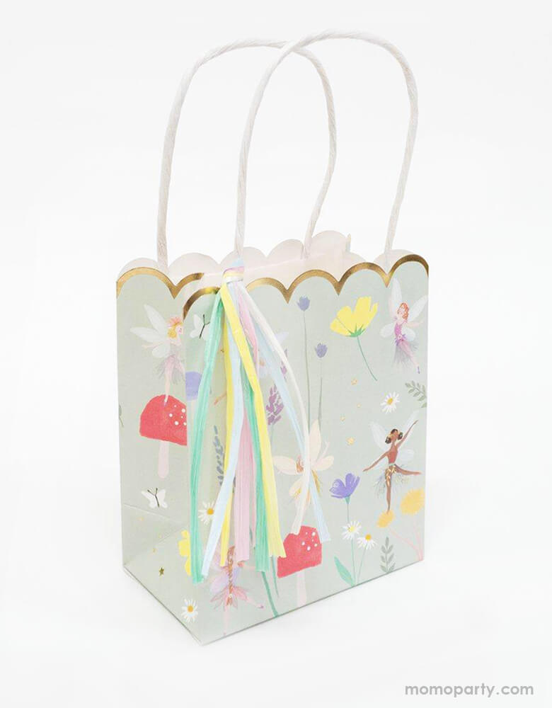 Side view of Meri Meri Fairy Party Bags. 5 x 6 x 3 inches. They are crafted with a stylish scallop edge and feature illustrations of dancing fairies, flowers and toadstools, and golden foil detail. The bags have twisted paper handles and gorgeous raffia tassels.