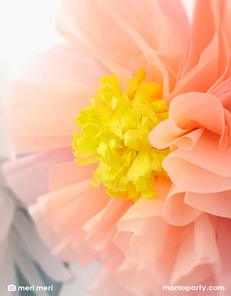 A close up of Meri Meri's 8.5 ft pre-strung giant flowers in bloom garland featuring beautiful flowers in peach, white, dusky blue,cream, yellow and dusky pink, made with tissue paper, along with green leaves, perfect for an Easter celebration or garden themed birthday party or gatherings in springtime.