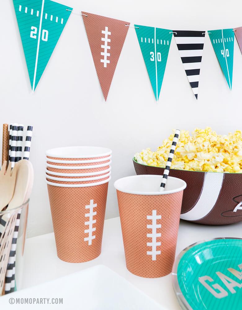 kid football themed birthday party with classic football printed design paper cups, Football Tailgate banner, popcorn in a bowl, great for a football viewing, Super Bowl or tailgate party!