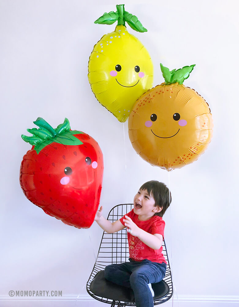 boy playing with fruit shaped lemon and orange and Strawberry Foil Mylar Balloons
