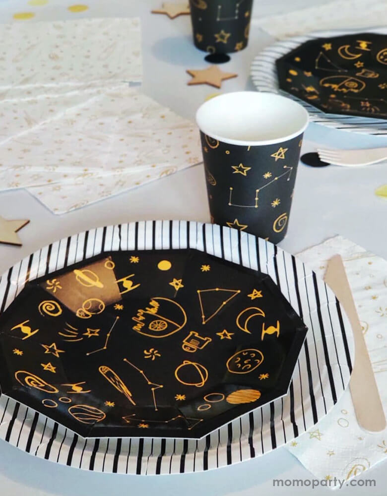 Space themed party table with Pooka Party - Galaxy Party plate layered with black stripe plate, Galaxy cups, Galaxy Napkins, and wooden utensils surround it. This Galaxy Collection Featuring yellow galaxy themed design on the black color tablewares, these partyware are inspired on space adventures and will take your decoration to another dimension! Modern stress free party supplies for kid space themed birthday party, blast off birthday party, star wars themed birthday party, Galaxy Party