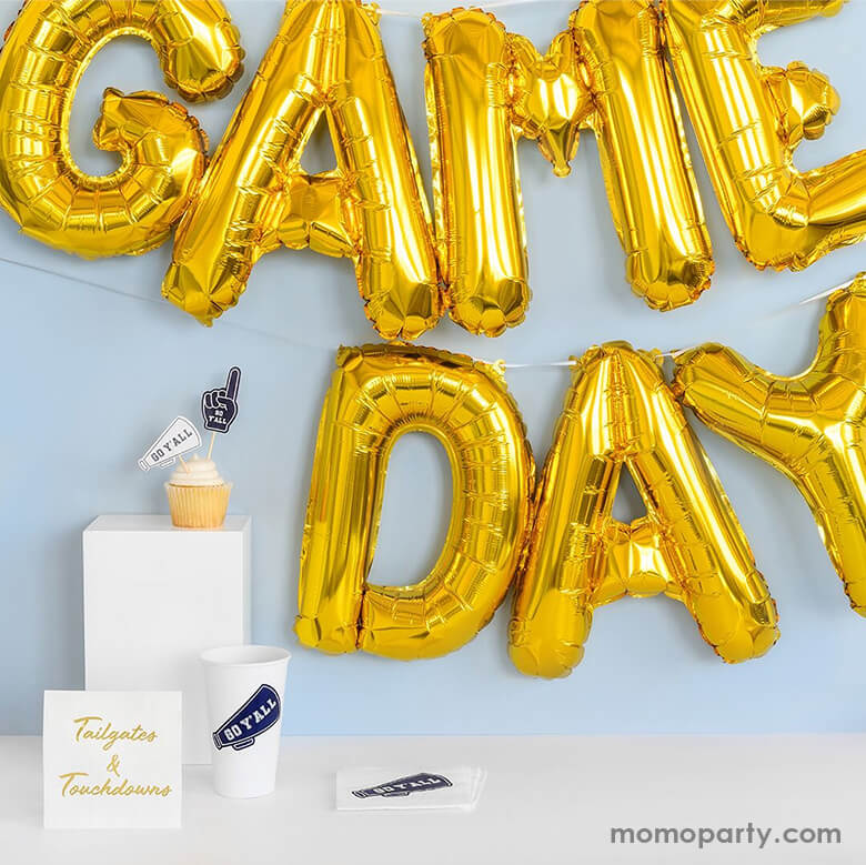 Celebrated Game day with Coterie - Game day collection, a Gold Game Day Foil Balloon Banner hanging on the wall, cupcake with Go Y'all Mini Toppers,  Go Y'all Paper Party Cups and napkins. Decorated with it in your sports themed party, game day or Let your guests know that it's game on with these gold foil balloons that will ensure your party stands out from the pack