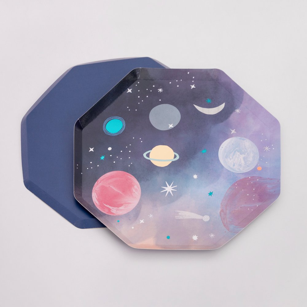 Space Dinner Plates By MeriMeri. Set of 8, Featuring a fabulous planet illustration design with Shiny blue foil and eye-catching silver holographic shiny foil details. With Navy print on the back of the plate. These awesome space plates are crafted from high quality card, so are practical as well as looking out of this world. Perfect for a space themed birthday, blast off birthday, two the moon birthday party or all type of space themed event and celebration  
