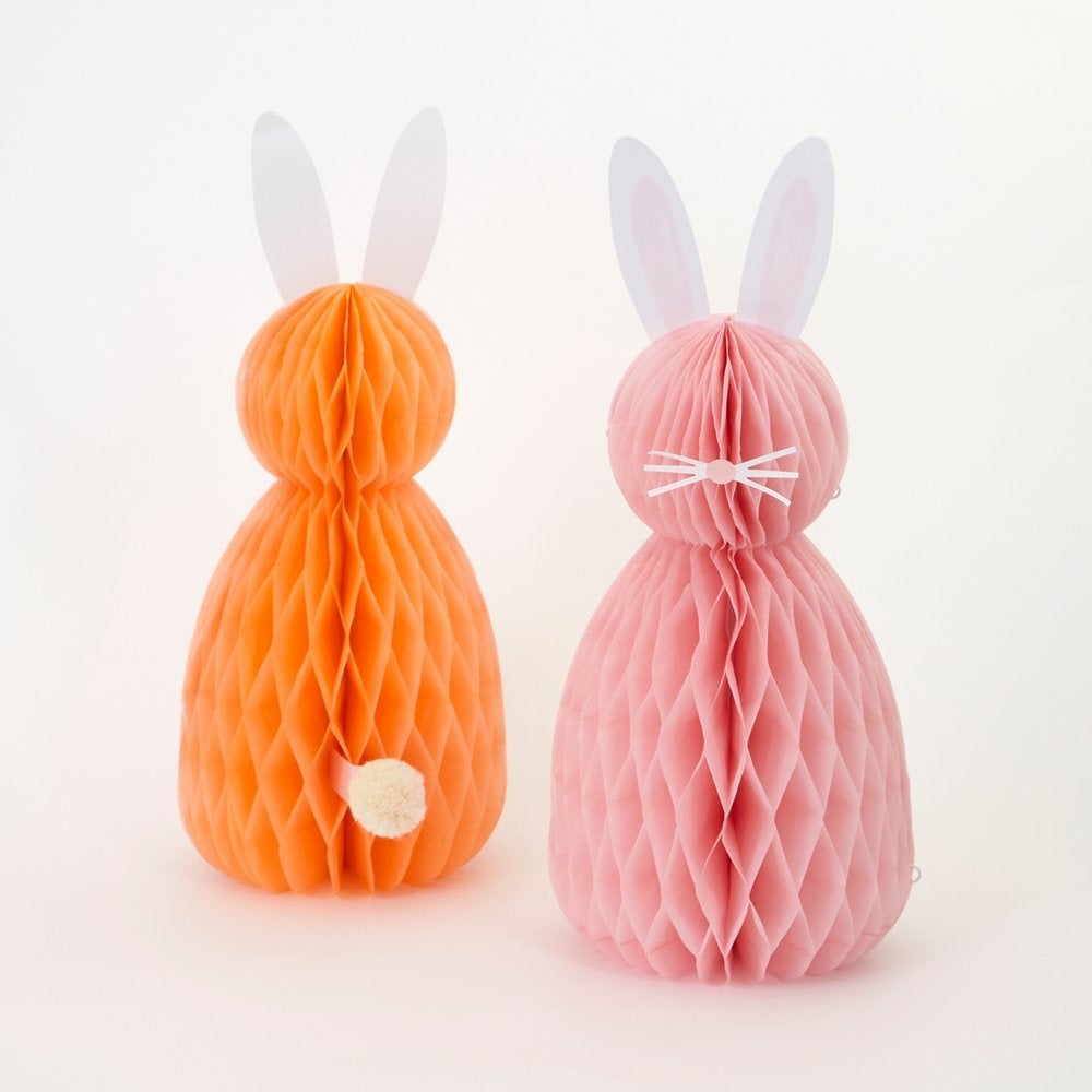 Meri Meri - Easter Honeycomb Decorations. Close up look of back look of orange bunny with amazing paper tissue honeycomb details, paper ears and pompom tail. Front look of A pink honeycomb bunny with paper ears, nose and whisker stickers. This high quality easter decoration is perfect for your easter party table, spring party, farm themed party, easter basket decorations, home decoration for easter.