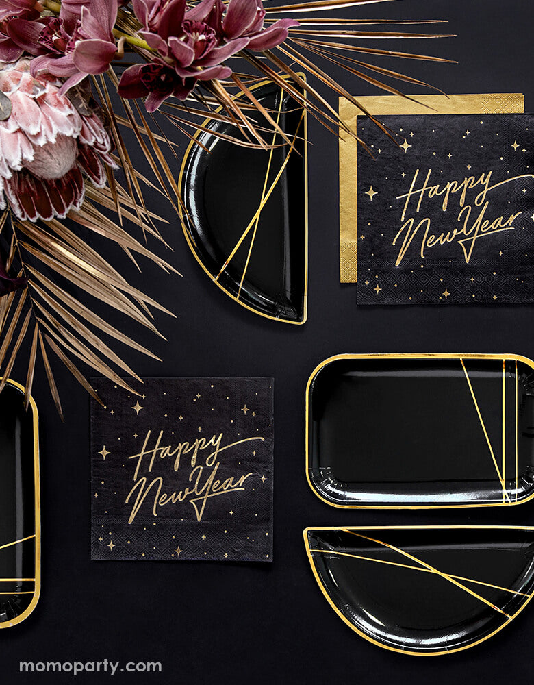Black and gold new year party table set up with Party Deco - Happy New Year Large Napkins layered with gold napkin, black and gold foil special shaped party plates, Floral as centerpiece in a black table top. Ring in the New Year in style with this gorgeous Happy New Year party collection with gold foil detail. This black and gold new year collection is the perfect party tableware for a new year party!