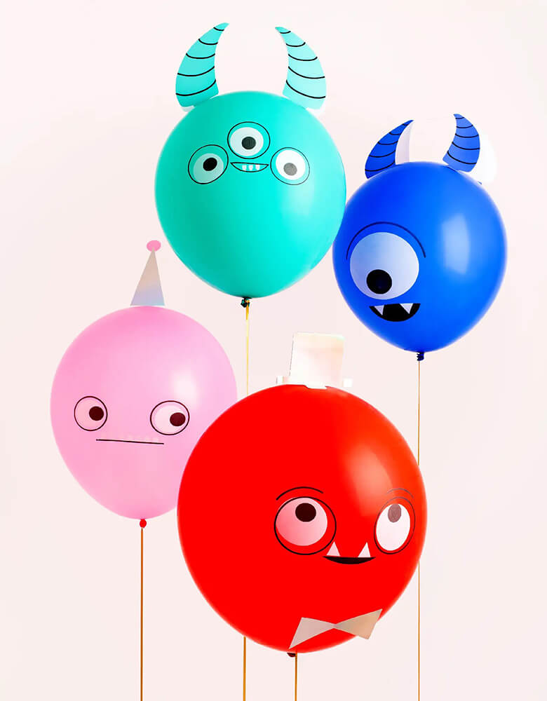 4 bright latex balloons inflated and decorated as monsters with hones and googly eyes, perfect for a Halloween party