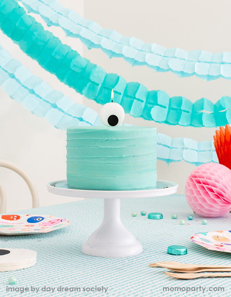 party table look with Little Monsters Large Eyeball Candle by Jollity & Co Party Boutique - Daydream society collection on top of modern pastel mint buttercream cake. Little Monsters Large Plates, and eyeball napkin on the table with mint stripe tablecloth, mint and light blue Crepe Paper Streamers as backdrop. Super modern cute collection for Little Monsters themed birthday party, halloween party or monster inc themed birthday party