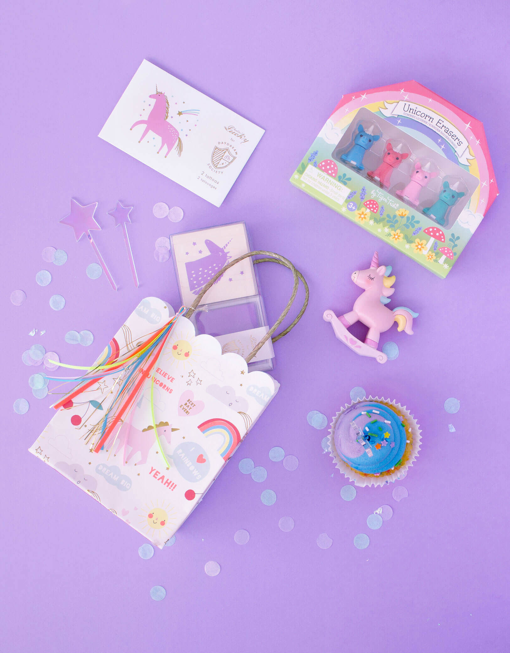 Magical Unicorn party favor bag with Day Dream Society Magical Unicorn Rubber Stamp, Unicorns & Rainbows Temporary Tattoos, Schylling Mini Unicorn Erasers, Unicorn mini wooden toy inside of Meri Meri Rainbow & Unicorn Party Bag