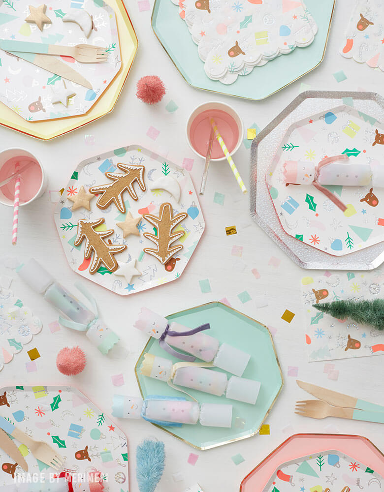 A mixture of Meri Meri's Holiday tableware featuring mint and pink dinner plates with Christmas icons design