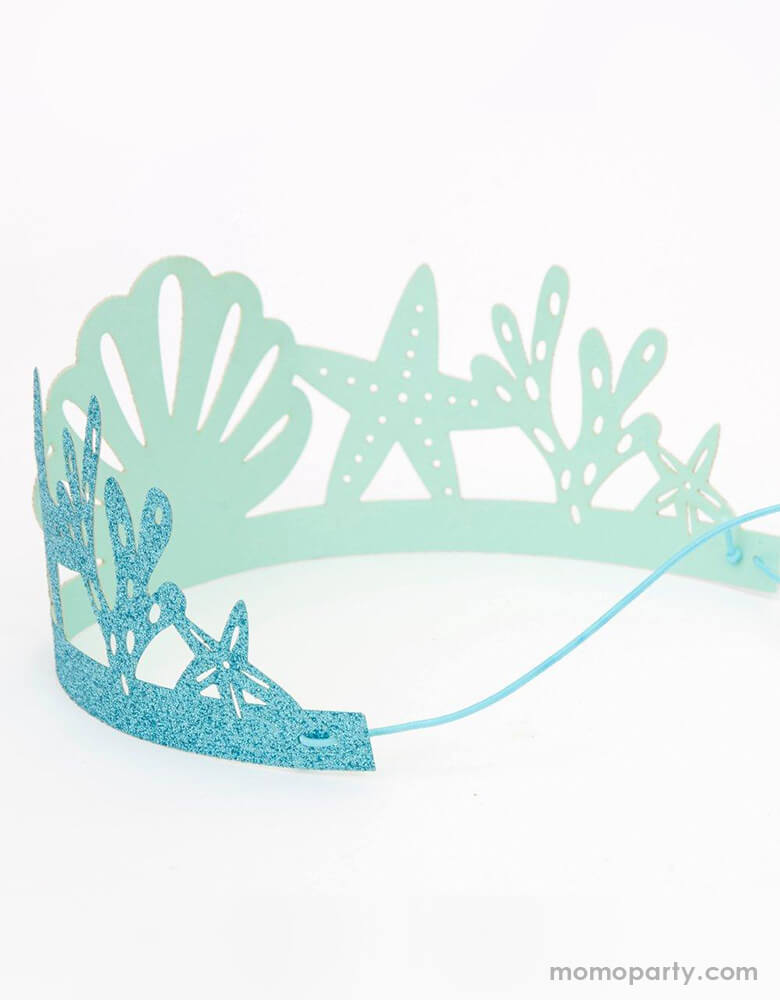 details of back side of Meri Meri Aqua Blue Glittered Mermaid Party Crown. Featuring gorgeous designs of starfish, shells and sea plants, these crowns are crafted with lots of shimmering eco-friendly blue glitter for a dazzling effect. With blue elastic to safely secure them when worn