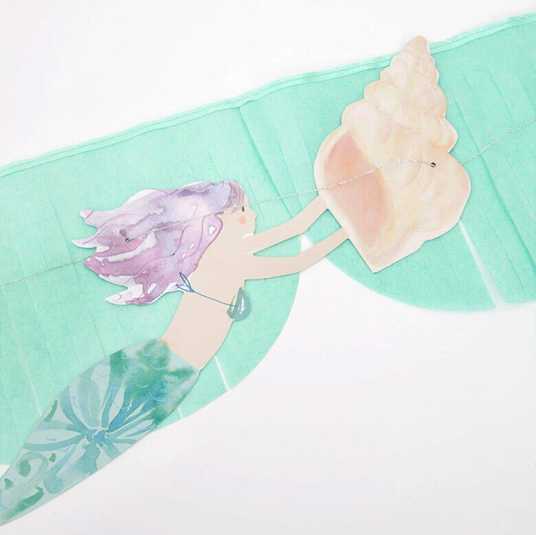 close up details of Mermaid Fringe Garland, a watercolor mermaid holding a seashell design