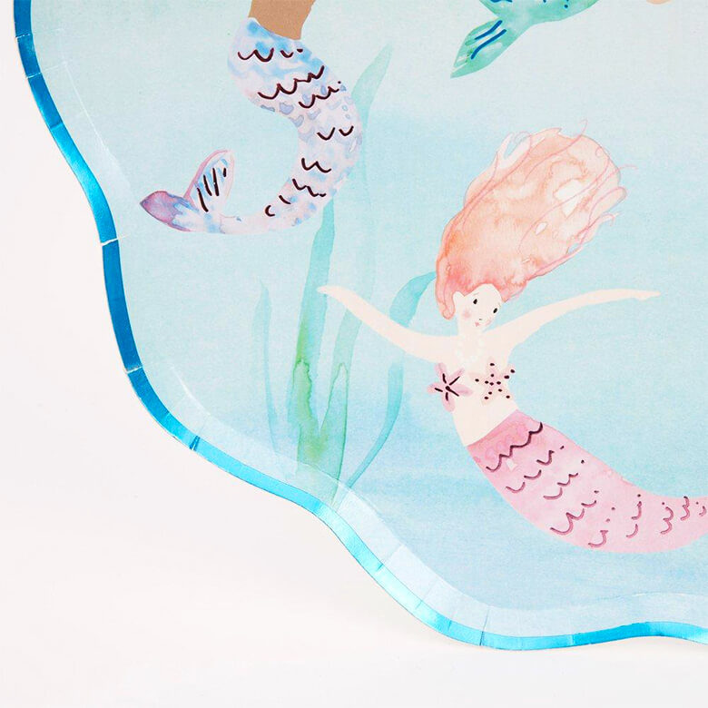 Details of Meri Meri Mermaid Swimming Plates. featuring a beautiful watercolor illustrated mermaid under the sea, with shimmering blue foil detail on the edge of the plate. The plate crafted in a sensational shell-shaped design. This gorgeous shell-shaped plate has so much details, it will look amazing at a mermaid party or under-the-sea party