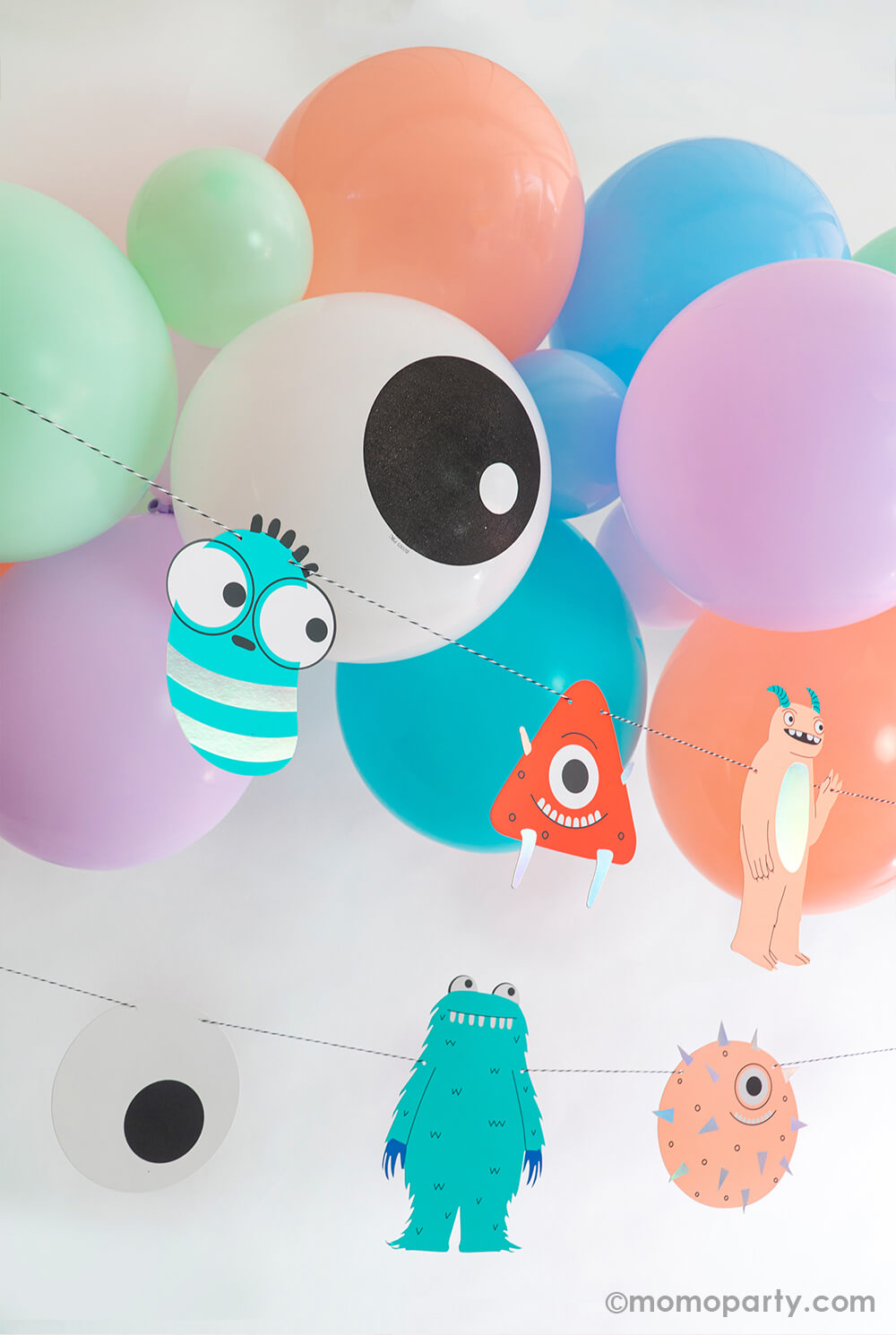  cute balloon garland in cheerful but soft colors of coral, blush, lavender, mint, aqua and pale. With pops of eyeball print balloons and this adorable purple monster foil balloon, it sets the monster theme for the party but with a friendly vibe for the little ones!