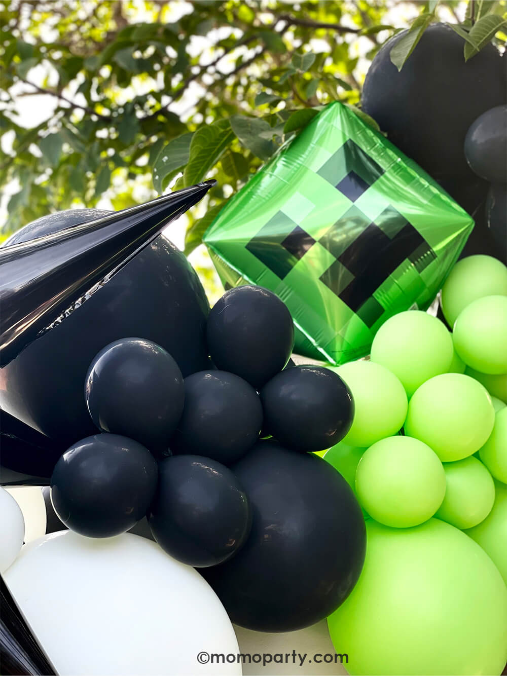 Minecraft themed Birthday Party Ideas by Momo Party. Close up look of modern party Backdrop with minecraft themed color balloons in green, black, white, and creeper foil balloon, black starburst foil balloon.