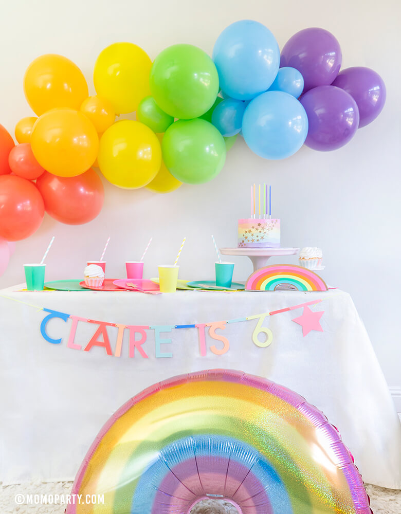 Rainbow theme Modern birthday Party, Momo party in a box included Oh happy Day Large Rainbow Plate Set, Oh happy day Rainbow Plates, Rainbow Cup Set, My minds Eye's Hip Hip Hooray Fringe Small Napkins, Hyper Tropical Wooden Cutlery Set, Mixed Pastel Striped Straws, Holographic Pastel Glitter Rainbow Foil Balloon, Mixed Rainbow colored Balloon Garland, for a girl's 6 years old Rainbow themed birthday party