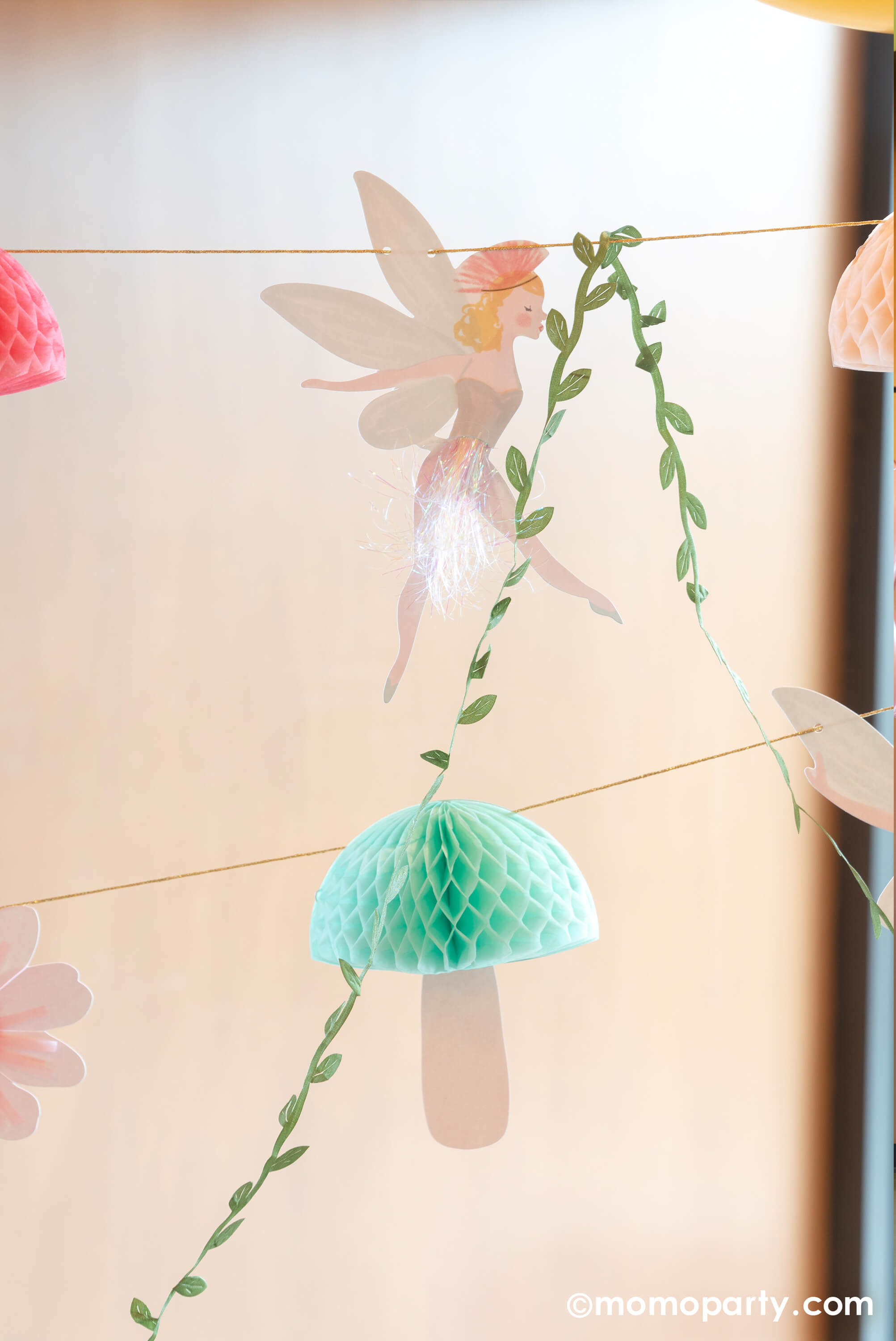 A close up to Momo Party's 10ft fairy garland. This beautiful garland will make a fairy or princess party look extra special. It features fairies, flowers, leaves and funghi, with lots of gorgeous embellishments.