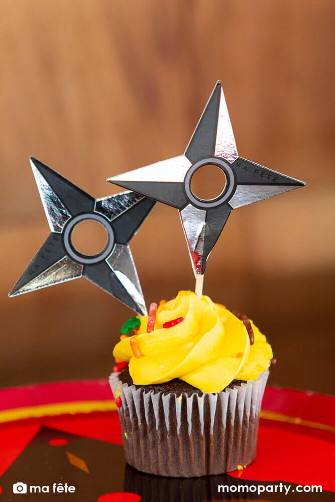 Momo Party's Ninja Cupcake Kit by Ma Fête. Featuring Ninja darts cupcake toppers on the cupcake, The toppers include gold foil details to give cupcakes an eye-catching finish. They are perfect for a Ninja themed birthday party