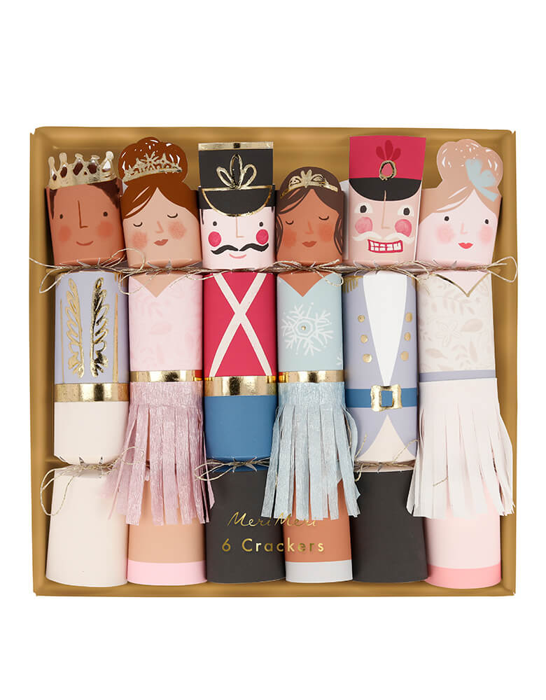 Meri Meri 217612 Nutcracker Character Crackers.  Set of six contains a gold foil paper hat, a joke, and an etched wooden Nutcracker character brooch, with a gold tone pin. Featuring the main Nutcracker characters, Each cracker is tied at the top and bottom with gold metallic thread, The three female character crackers have skirts made with fringed pearlescent crepe paper, The pink fairy cracker has paper wings with gold foil detail. Prefect fun gift for the Holiday season! 