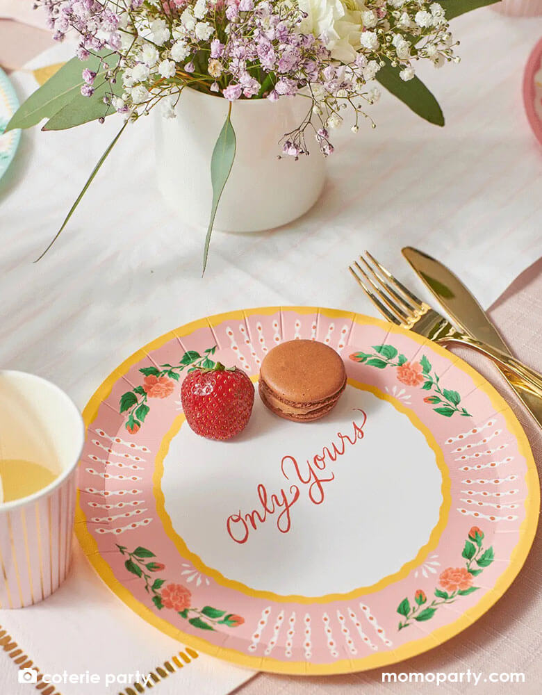 A beautiful love themed party table featuring Momo Party's 9 oz pale pink pinstripe party cups by Coterie Party and 9" All You Need is Love Large Plates with a message of "Only Yours" on the plate. With a table set with pastel pink themed tableware with heart shaped elements, it's a perfect inspiration for a Valentine's Day celebration.