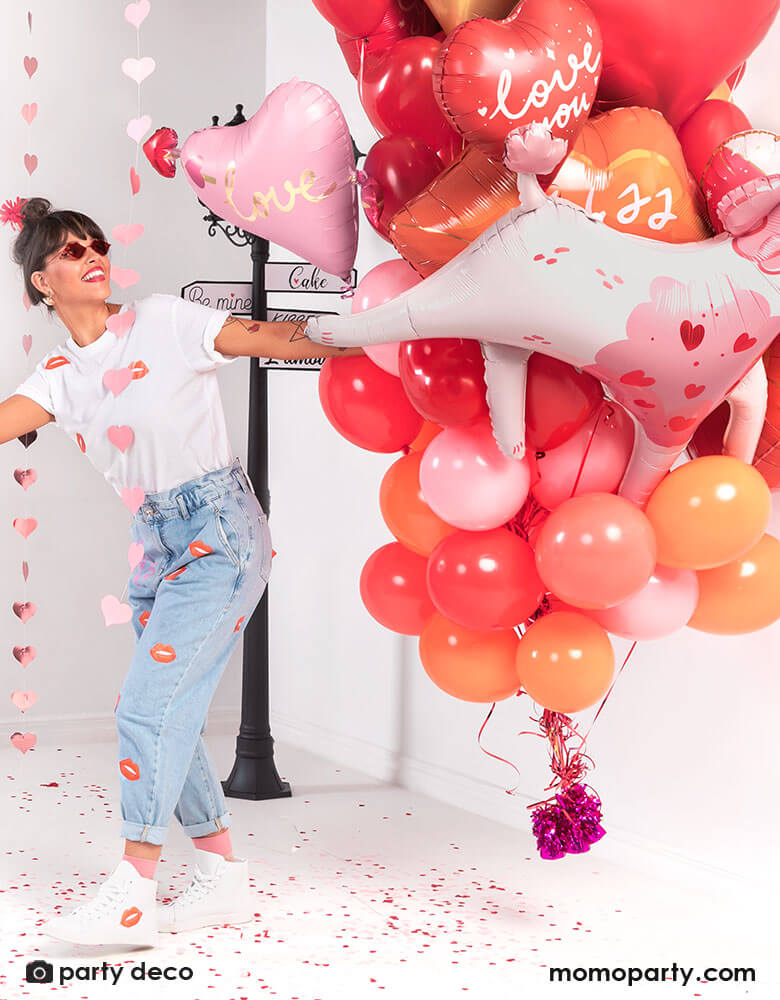 A girl holding a bouquet of Momo Party's red and pink heart-shaped balloons, celebrating Valentine's Day.