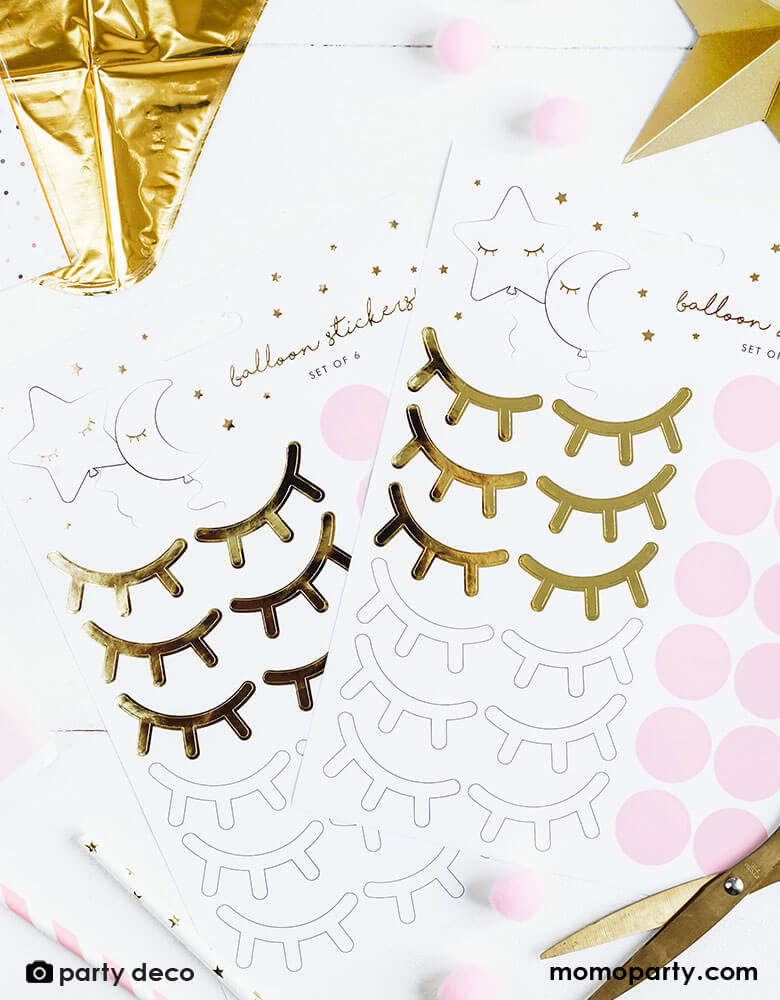 A craft table with Party Deco's Little Star Foil Balloon sticker sheet which contains 6 pairs of eyes and 6 pairs of blushes, along with foil balloon and scissors for an easy DIY balloon decoration project - great for a baby shower or a twinkle twinkle little star themed birthday party