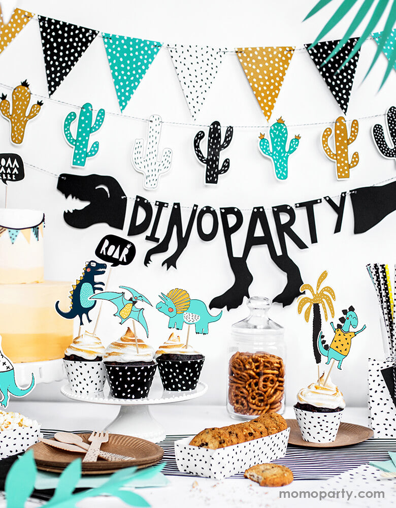 modern dinosaur party set up idea with Party Deco - Dinosaurs Flags Garland, Dinosaur garland, Cactus garland with Spotted dots pattern in mustard, black, mint and white colors hanging on the wall as backdrop, cookies, and cupcakes on the black and white dots paper containers, Pretzels in a Jar, with black stripe table runner,   This simple modern Dinosaur Party is perfect for Kids Party Decoration, Dinosaur Cactus Party Decorations, Dinosaur Decorations, Dinosaur Party.