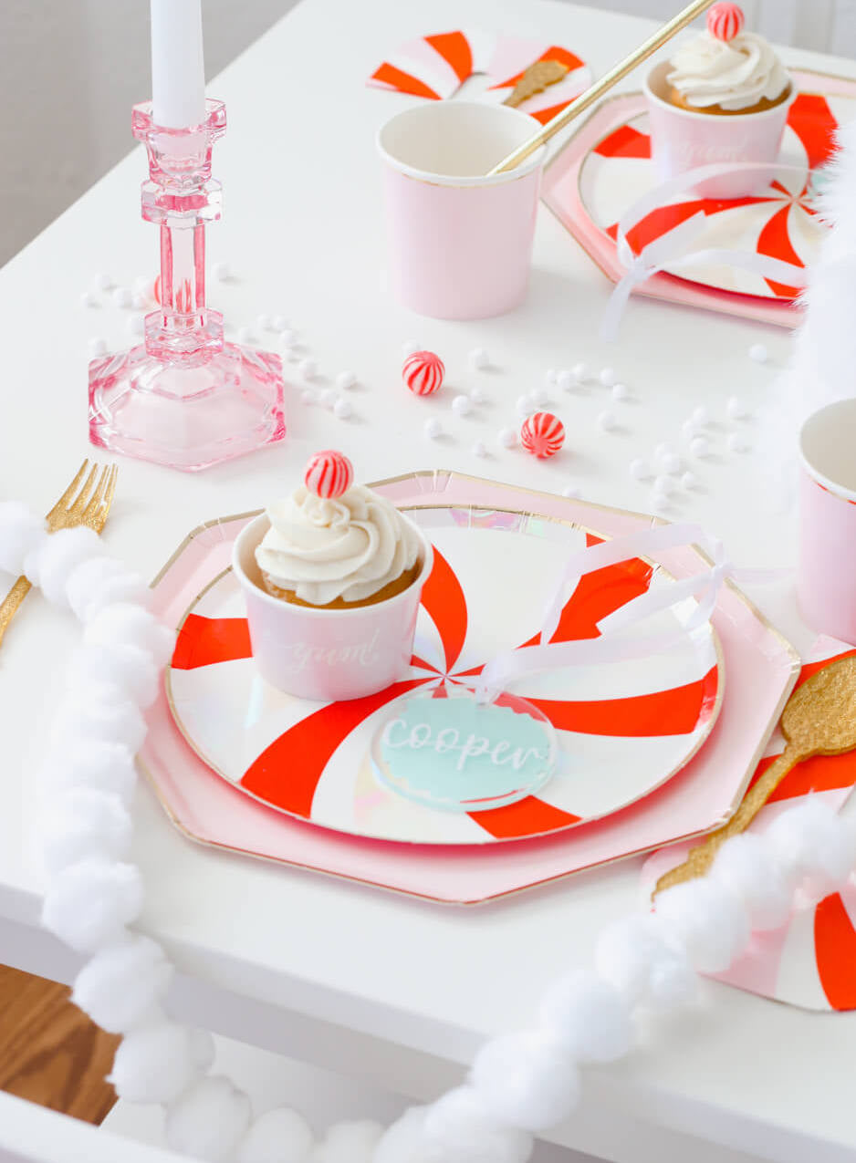 A Christmas Party Tablescape idea with Peppermint Plate Layerd with Dusty Pink Plates, along with candy cane napkins and pale pink tumbler cups