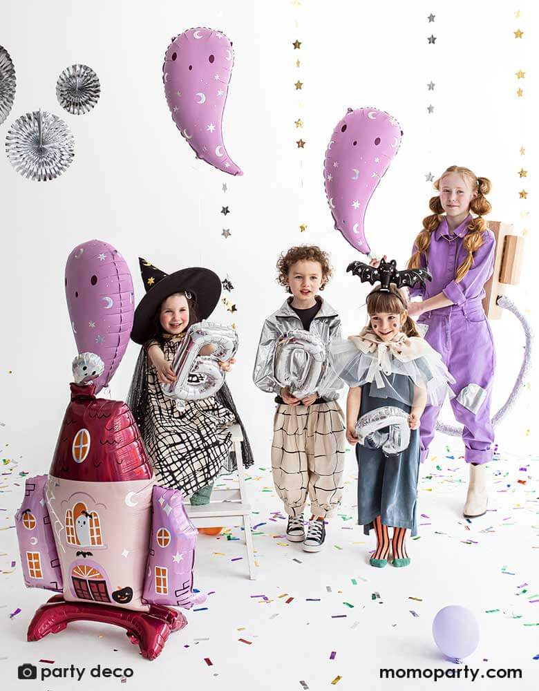 Kids party with a bunch of Halloween balloons in the shape of pink ghosts, a pink haunted house, perfect for a not-so-scary kid-friendly Halloween party