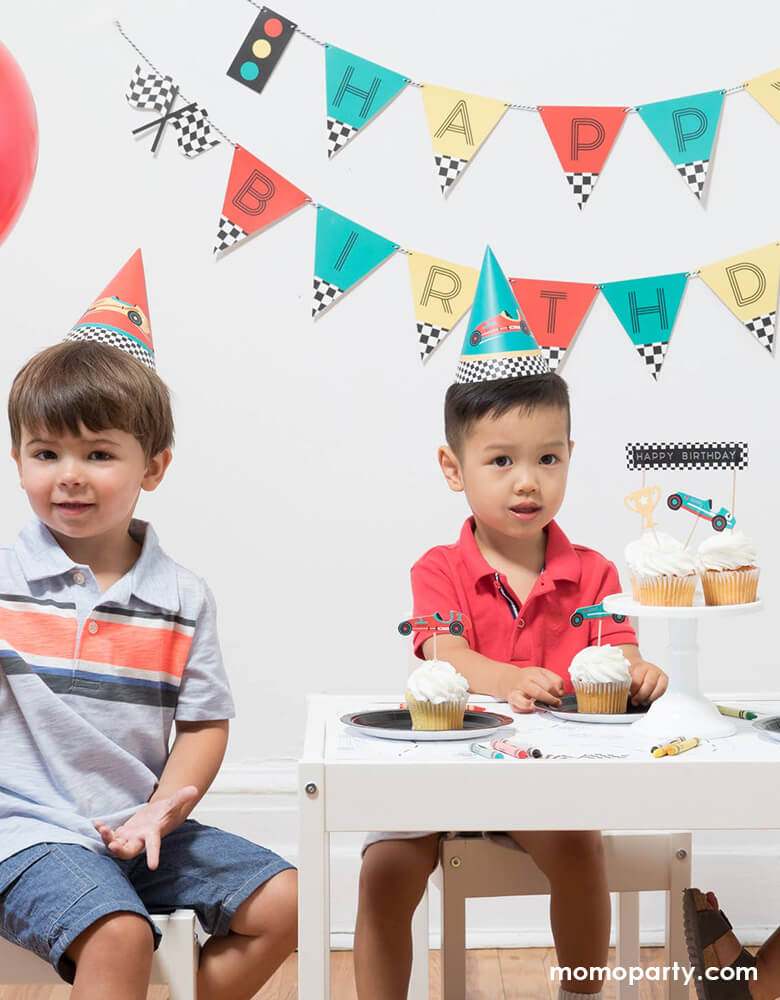 Boys wearing Race Car Party Hats and eating cupcakes at a Vintage race car birthday party