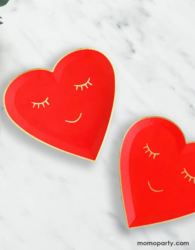 Momo Party's 7" red blushing heart shaped plates. Come in a set of 8 plates, these red heart shaped plates have a smiling face on them in gold foil accent, they are perfect for a kid's oriented Valentine's Day celebration.