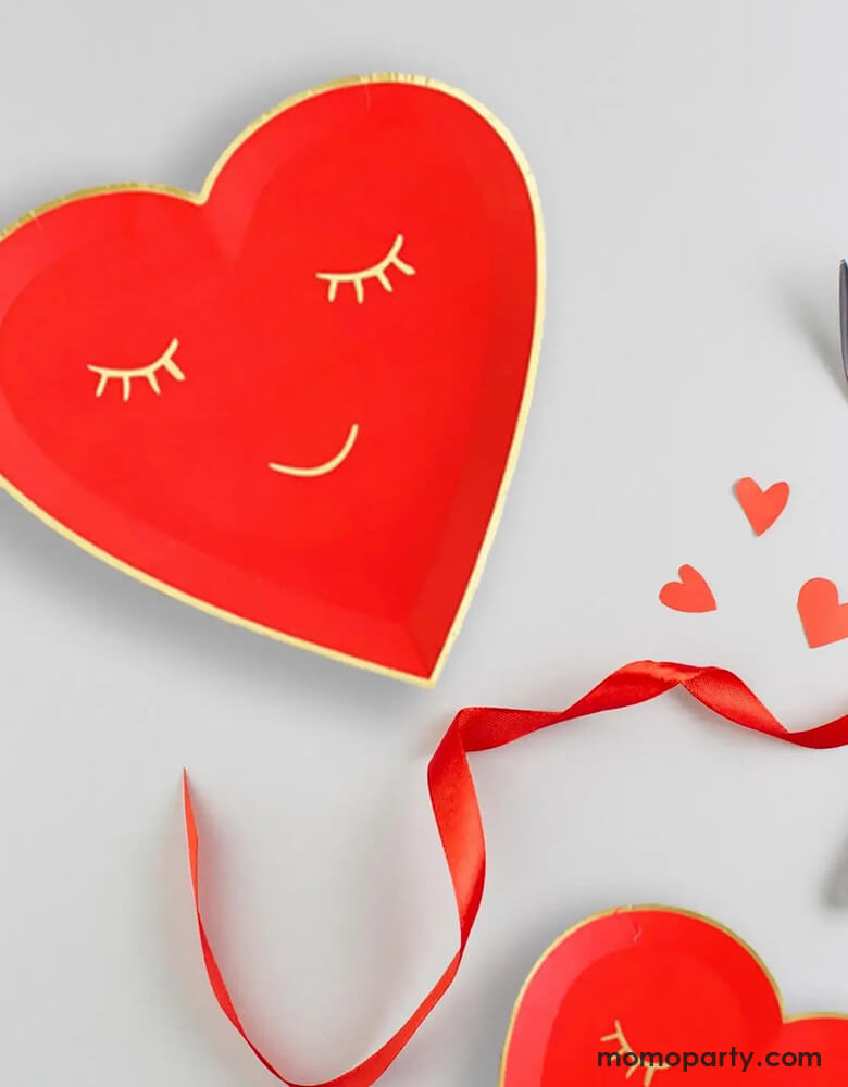Momo Party's 7" red blushing heart shaped plates. Come in a set of 8 plates, these red heart shaped plates have a smiling face on them in gold foil accent, they are perfect for a kid's oriented Valentine's Day celebration.