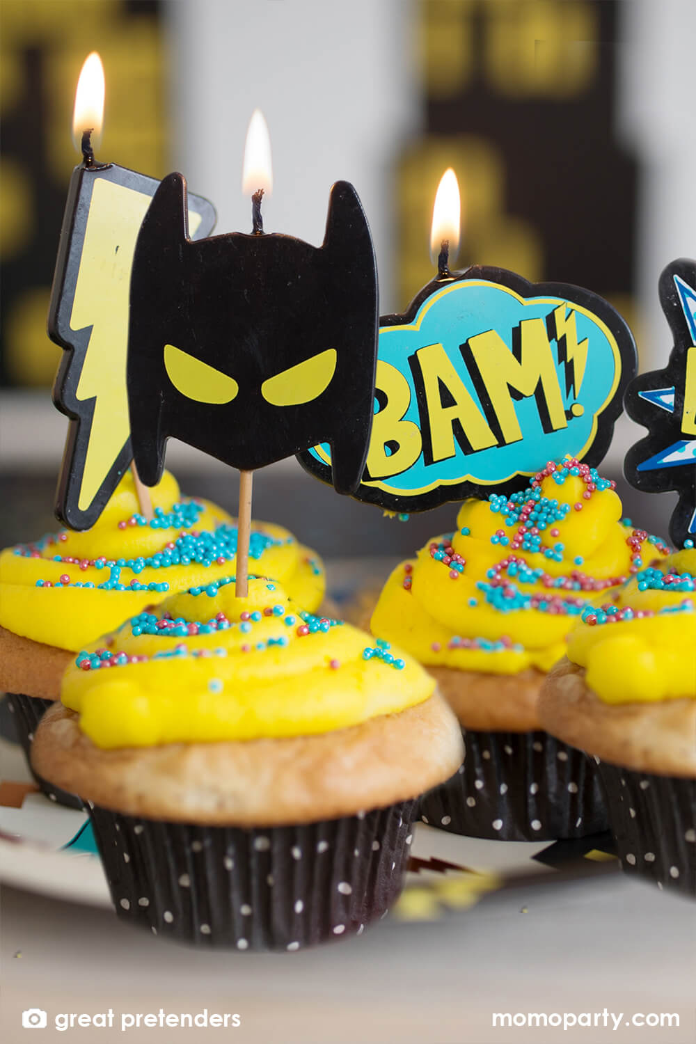 Superhero Candles set by Great Pretenders. Featuring a heroic mask, two comic action bubbles, and a lightning bolt shaped candle on cupcakes with yellow butter and sprinkle decorations. These candles are a simple way to bring a cool factor to your cake. 