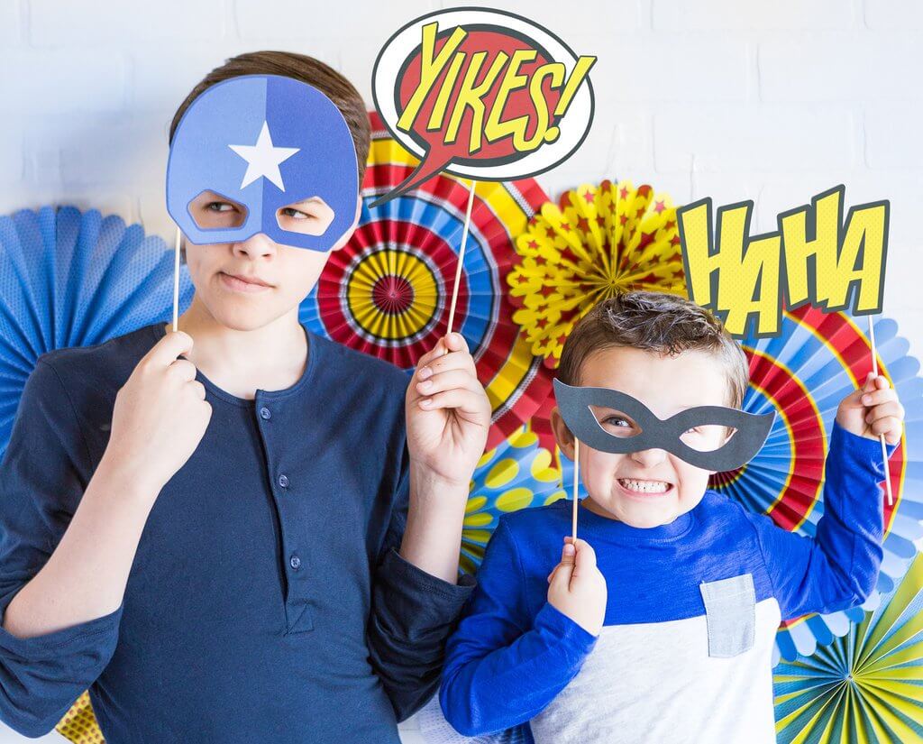 Kids playing with My Minds Eye - Paper Love Comic Pop Photo Props at a Superhero Party