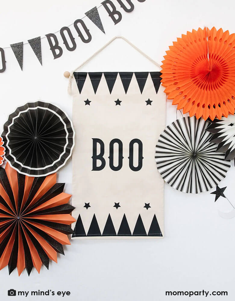 A vintage inspired boo hanging canvas with black and orange party fans around, with the retro style boo party garland hung next to it, it makes a great Halloween home decoration or party decoration this spooky season.
