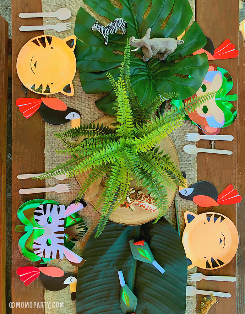 Safari Jungle Party Table Set Up with Tiger Paper Plates, Green Foil Palm Paper Plates, Animal Mask, Toucan Napkins, animal finger toys, snake blower as center piece decorations