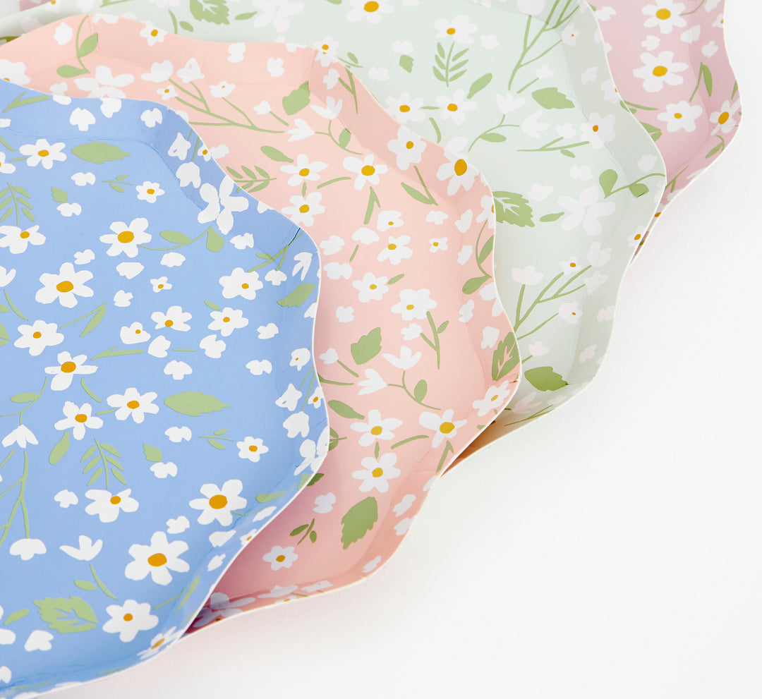 a Close up details of Ditsy Floral dinner Plates By Meri Meri. Features a fabulous floral pattern with a stylish scalloped edged paper plates. Pack of 12 in 4 colors: blue, green, pink and peach. Made from eco-friendly paper. Add a touch of springtime beauty to your party table with these high quality, well designed party plates.