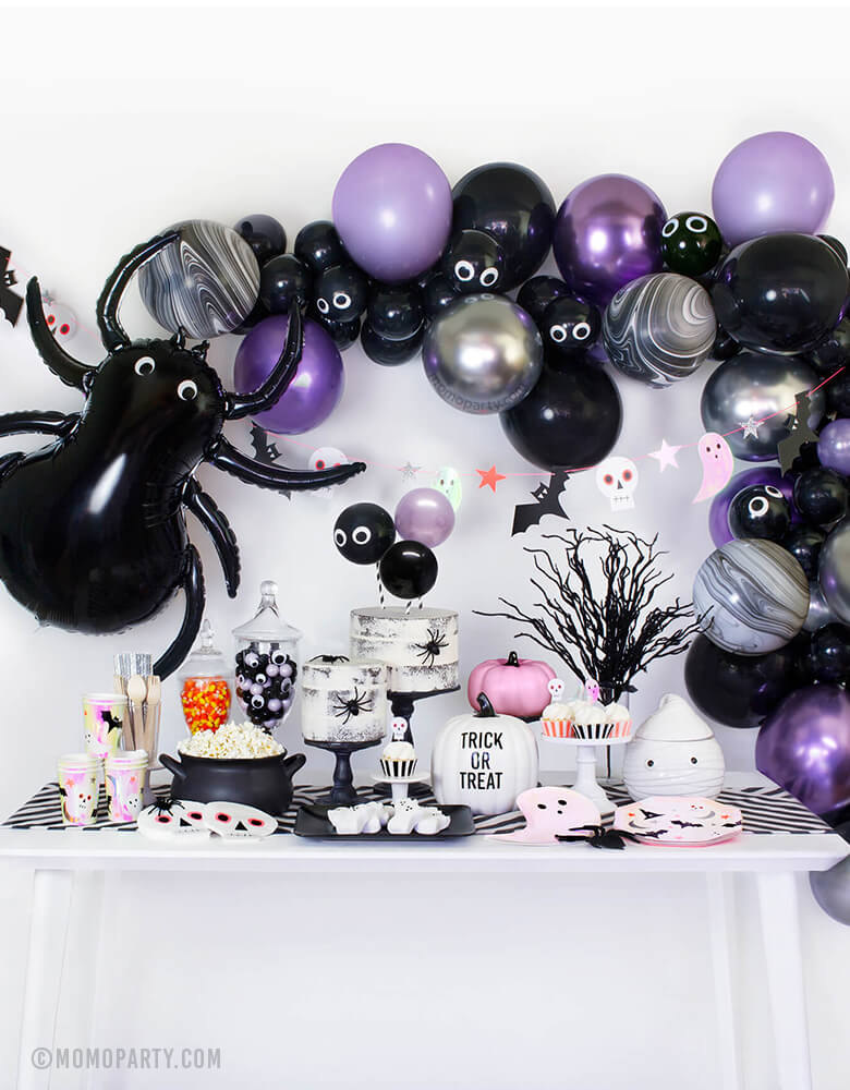 Momo Party Modern Halloween party in a box, party look with balloon garland, Meri Meri Spider Foil Mylar Balloon, halloween icon garland, table set up with MeriMeri Iridescent Ghost Plates, Halloween Icons Side Plates and cups, skull napkin, naked cake with spiders, googly eyes with gum balls in a jar, pink pumpkin decor, white pumpkin with "Trick or Treat", black witch pot with popcorns, party inspiration for for halloween party, trick-or-treat Halloween party, Haunted House Birthday Party