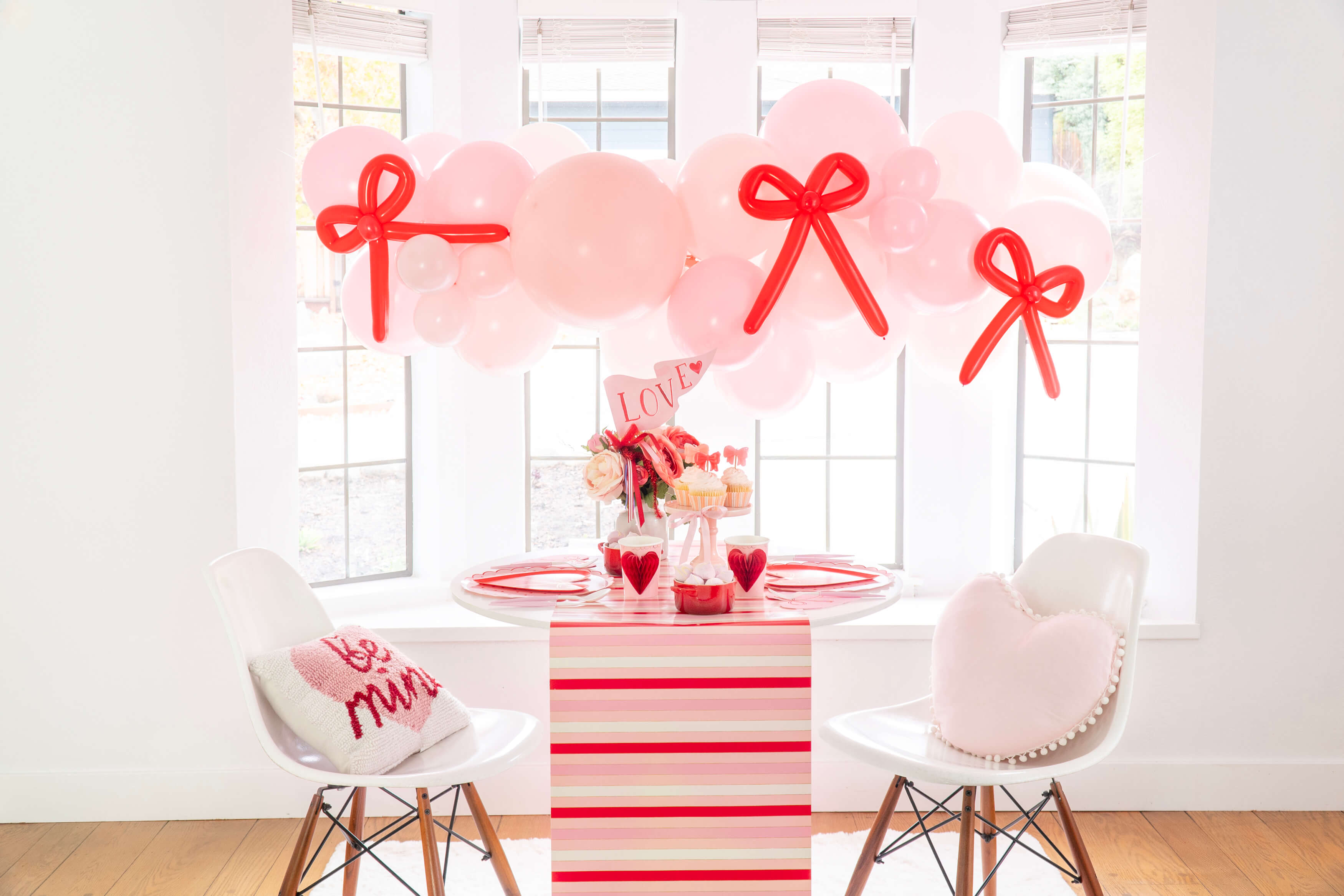 A pink and red bow themed Valentine's Day party decoration set up by Momo Party