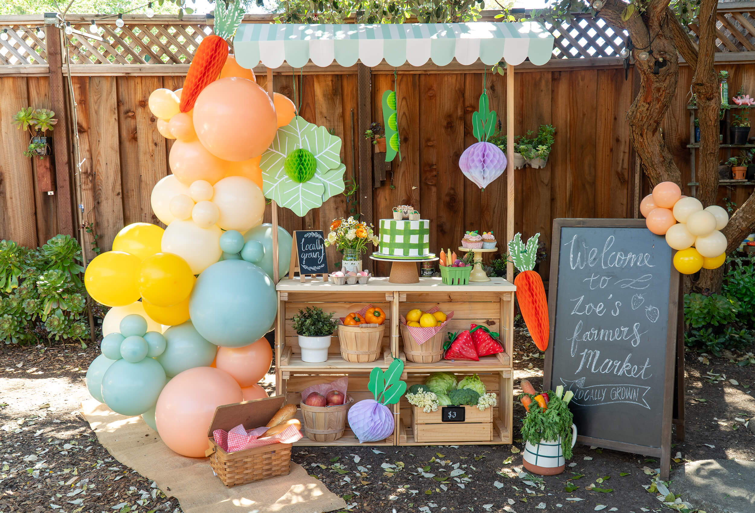 A kids’ farmer’s market party set up with fresh produce-themed party supplies, balloons and decorations by Momo Party.