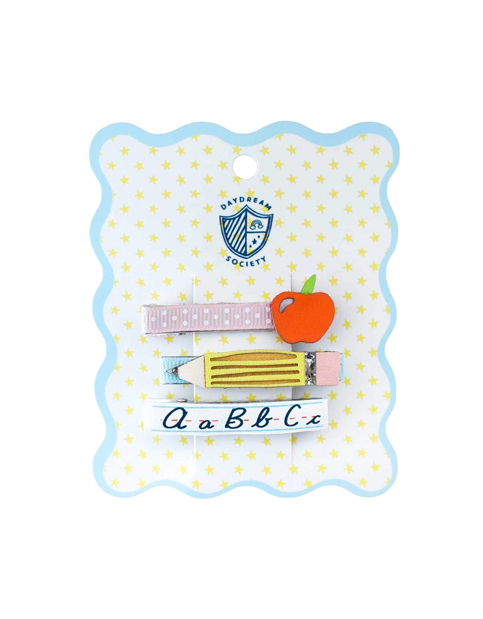 Momo Party's Smarty Pants ABC Hair Bar Clip Set by Daydream Society. Three hair clips, one with alphabet letters A, B, and C, one with pencil design, one with an apple design, on a polka dot card with wavy edge. These hair clips are perfect for school picture day, first day of school, and every school day in between.